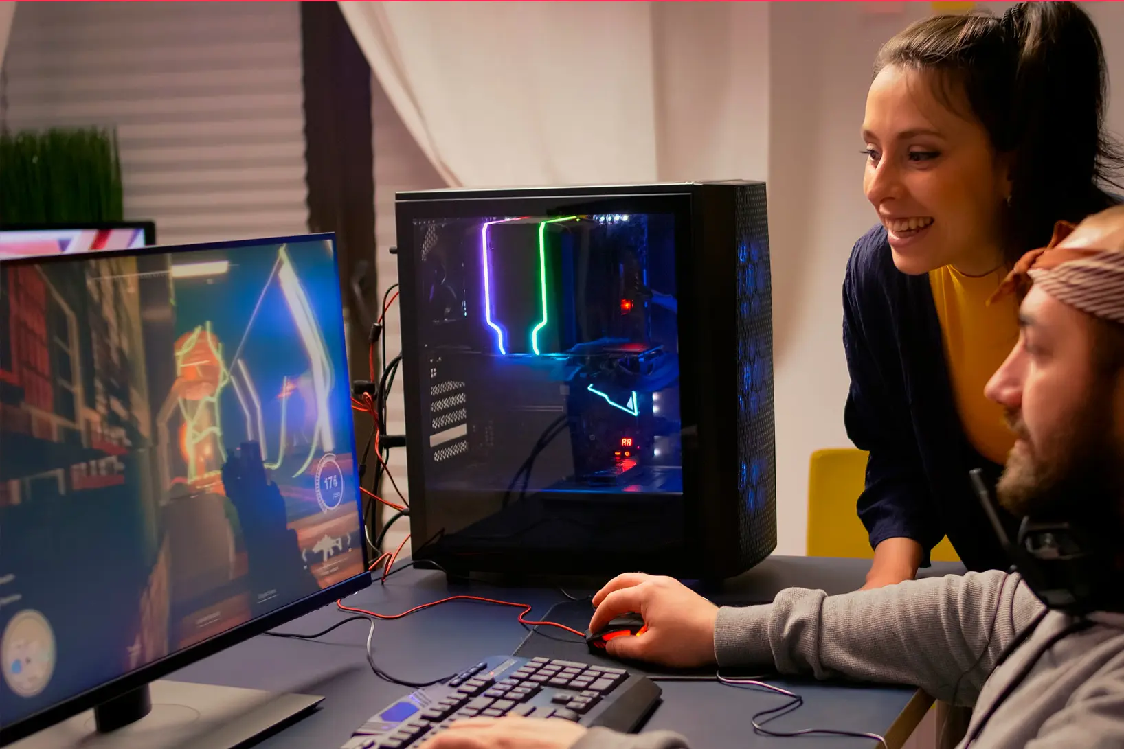 Desenvolvedor ou analista trabalhando em frente a um monitor grande que exibe uma interface gráfica complexa.