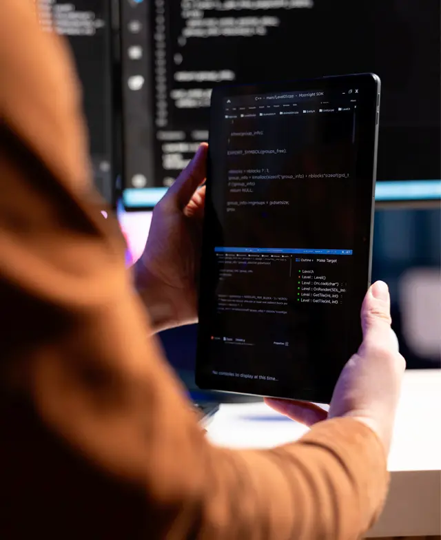 Close-up das mãos de um desenvolvedor digitando código em uma tela de computador